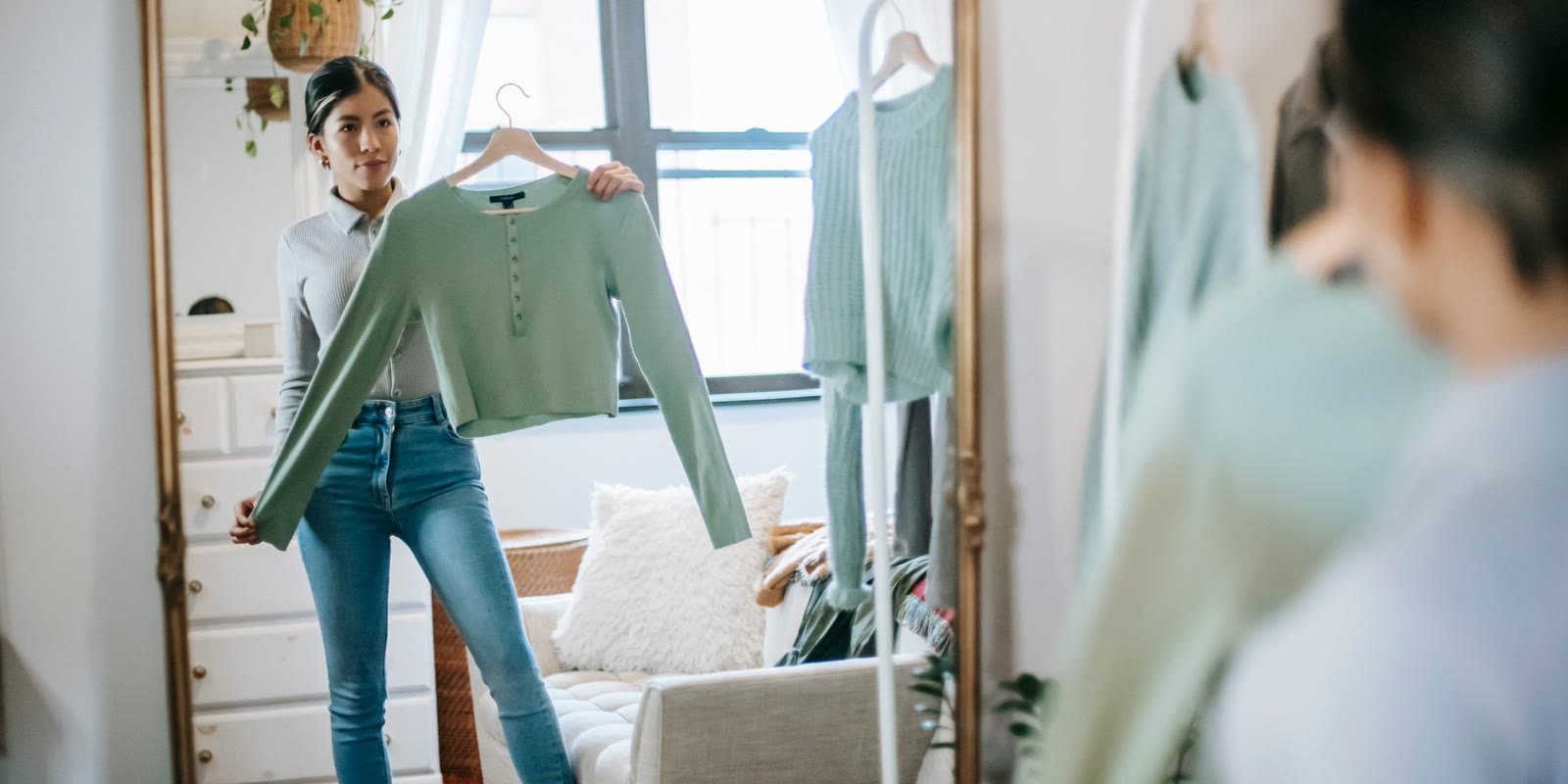 Woman choosing an outfit in front of a mirror