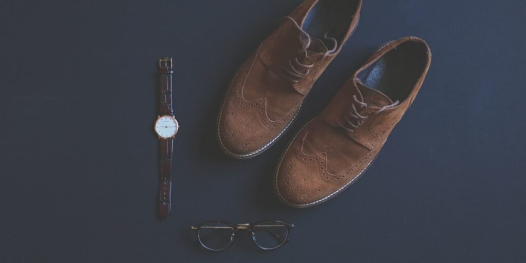 Brown leather brogues, wristwatch and glasses